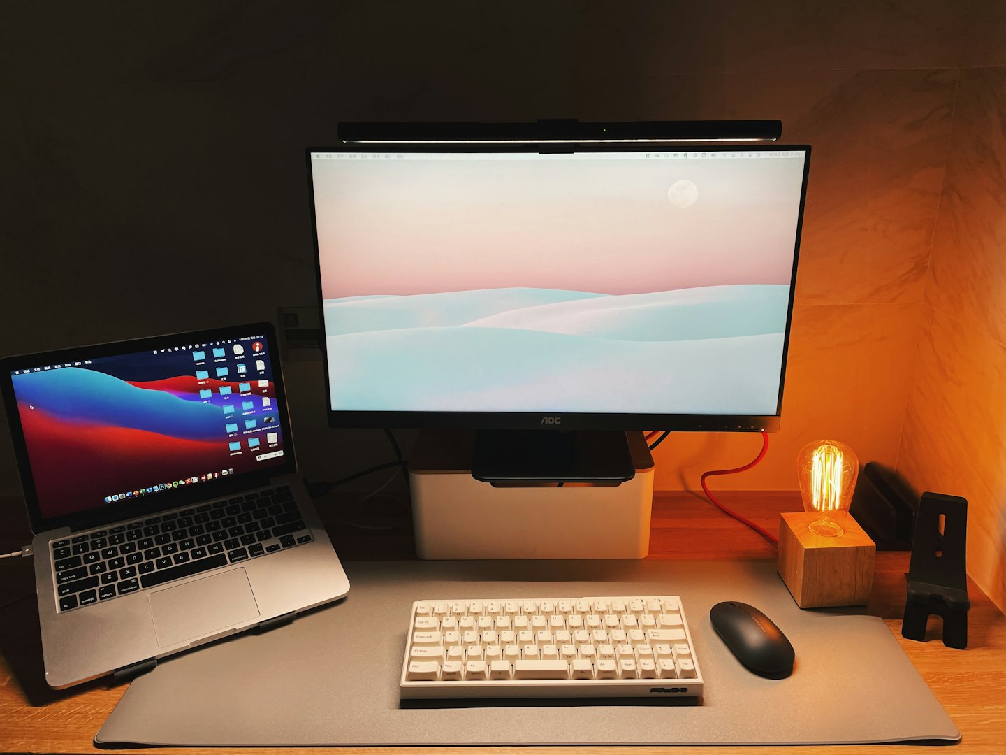 Laptop dan monitor berada di atas meja kantor kayu.